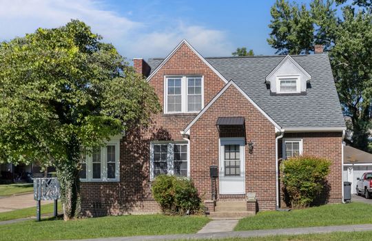Tudor Revival Style home, brick exterior, front door, shingle roof, landscaping