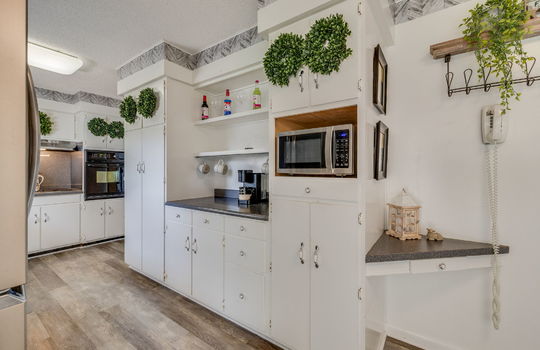 kitchen, cabinets, microwave, luxury vinyl flooring, built-in oven, cooktop, range hood