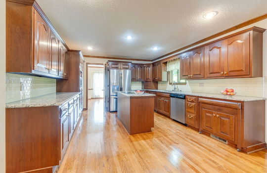 kitchen, cabinets, granite countertops, tile backsplash, stainless appliances, kitchen island, hardwood flooring, wall oven, refrigerator, sink, dishwasher, cooktop in island