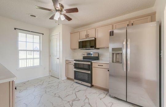 kitchen, pantry/storage closet, cabinets, countertops, stainless appliances, built-in microwave, oven/range, refrigerator, window, ceiling fan
