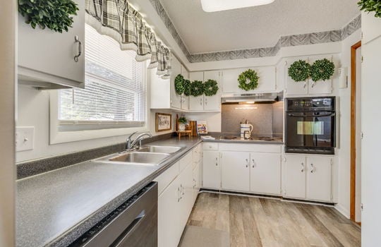 kitchen, cabinets, countertops, sink, window above sink, cooktop, range hood, built-in oven, luxury vinyl flooring
