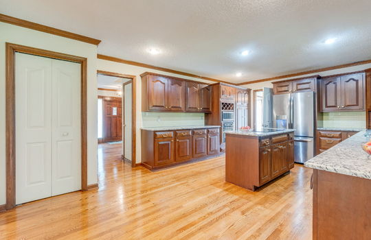 kitchen, cabinetry, pantry, hardwood flooring, cabinets, tile backsplash, granite countertops, stainless appliances, built-in microwave, built-in oven, cooktop