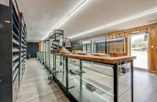 front glass entry door, vinyl flooring, glass display cases, shelving