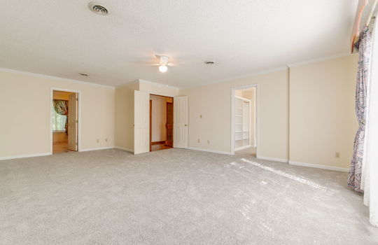 primary bedroom, carpet, walk-in closet, double doors, ceiling fan, windows