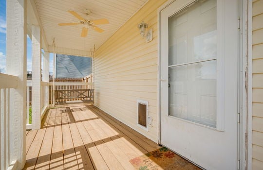 covered back porch, ceiling fan, vinyl siding, interior entry door, pet door