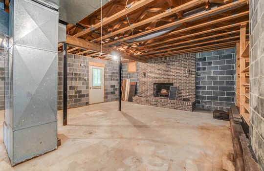 basement, fireplace, block walls, concrete flooring, exterior door