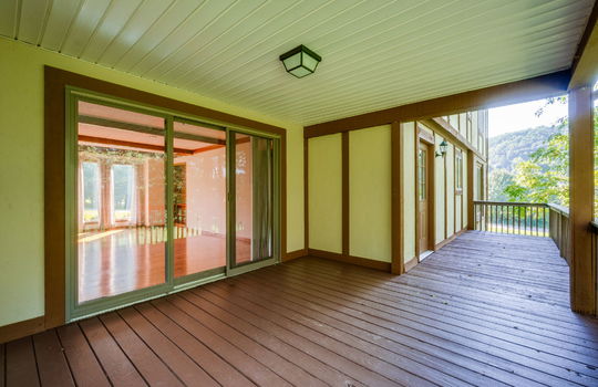 covered back deck, wood deck, railing, interior sliding glass door, wood siding, doors