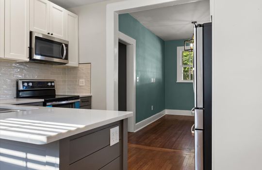 Kitchen, stainless appliances, island, built in microwave, oven/range, refrigerator, hardwood flooring, tile backsplash