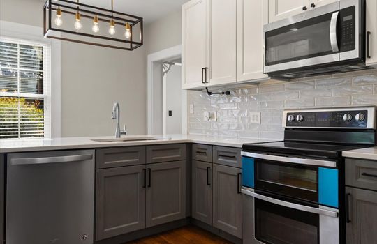 kitchen, shaker cabinets, counter tops, stainless appliances, dishwasher, built-in microwave, oven/range, tile backsplash, hardwood flooring, built in microwave, windows, chandelier lighting