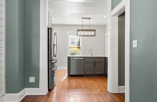 dining area view toward kitchen, refrigerator, dishwasher, cabinets, countertops, sink, window