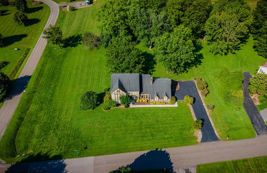 aerial view of home from front, front yard, driveway, road, sidewalk, shingle roof, tudor style home, back yard, trees
