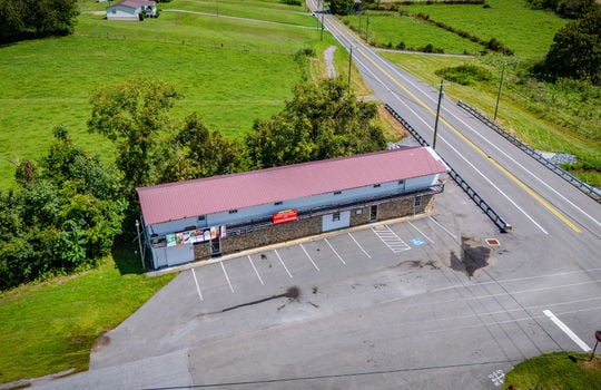 overhead aerial view of property, commercial space for lease, road, parking lot, parking spaces, metal roof, stone exterior