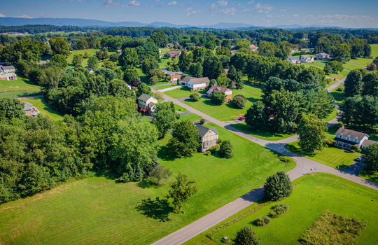 aerial photo of home, side view of home, road, back yard, side yard, front yard, neighboring homes, neighborhood, mountains