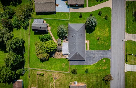 overhead aerial view of home, front yard, trees, landscaping, road, driveway, roof, shingle roof, back yard, landscaping, storage shed/outbuilding, fenced back yard