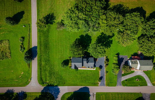aerial overhead view of home, front yard, back yard, road, driveway, roof, trees, neighboring homes