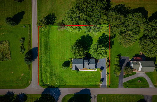 aerial overhead view of home, front yard, back yard, road, driveway, roof, trees, neighboring homes, property outline
