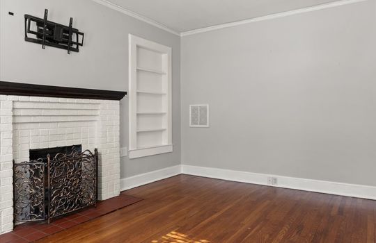 living room, built-in shelving, brick fireplace, hardwood flooring