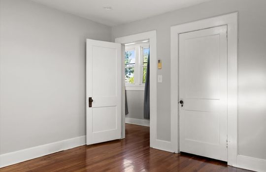 bedroom, hardwood flooring closet, door to hallway