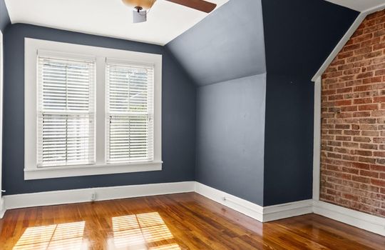 bedroom, hardwood flooring, exposed brick wall, windows, ceiling fan