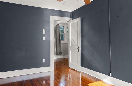 bedroom, hardwood flooring, ceiling fan, door to hallway