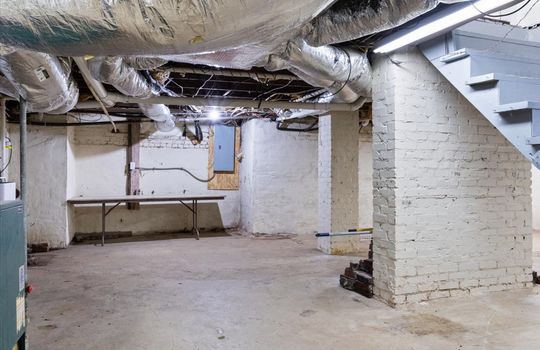 unfinished basement, concrete flooring, stairs to main level