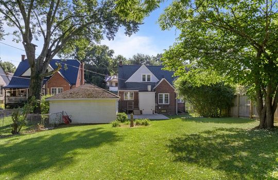 back of home, back yard, brick exterior, shingle roof, landscaping, fencing