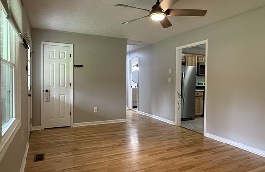 living room, coat closet, ceiling fan, windows, hardwood flooring, hallway, door to kitchen