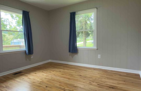 bedroom, closet, hardwood flooring, painted paneling walls, windows