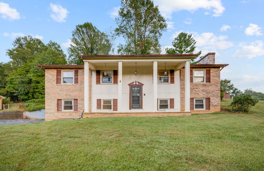 Split level home, brick, covered front porch, front yard, driveway, trees