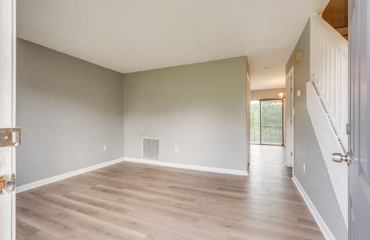 front door, living room, stairs to upper level, vinyl flooring