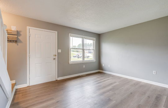 living room, front door, window, vinyl flooring, stairs to upper level
