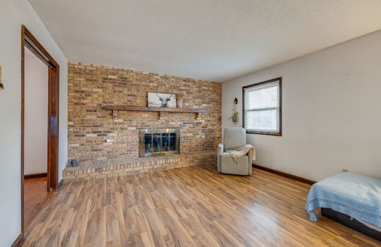 living room, hardwood flooring, window, brick wall, brick fireplace