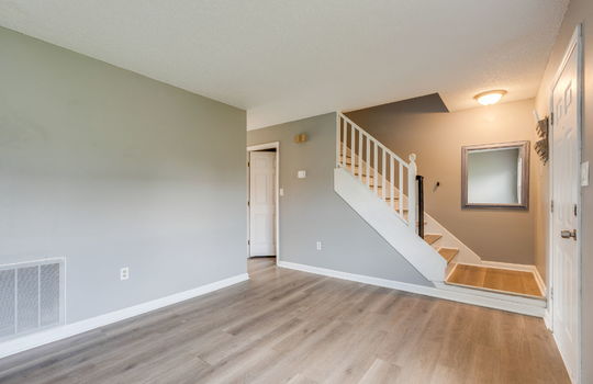 living room, front door, vinyl flooring, stairs to upper level