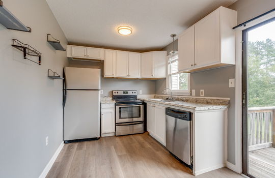 kitchen, refrigerator, cabinets, countertops, sink, dishwasher, oven/range, sliding door to back balcony, vinyl flooring
