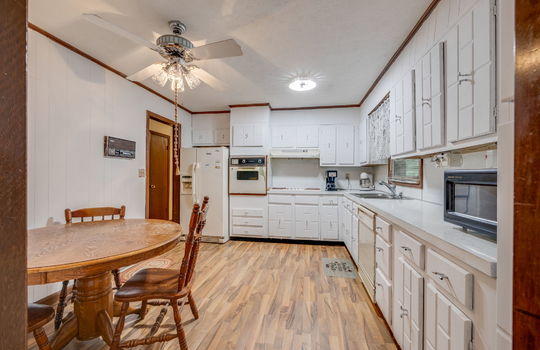 kitchen, kitchen cabinets, refrigerator, built-in wall oven, dishwasher, sink, cooktop, hardwood flooring, door to hallway, ceiling fan, sink, window above sink