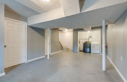 basement, laundry area, concrete flooring, closet, stairs to main level
