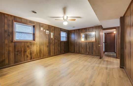 digitally altered to remove furniture, hardwood flooring, lower level den, paneling walls, door, steps to foyer