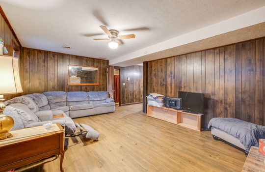 lower level den, paneling walls, hardwood flooring, ceiling fan