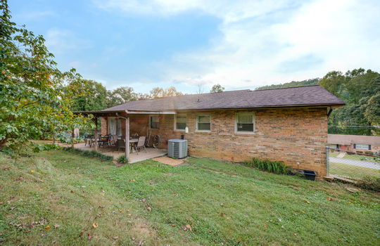 back of home, back patio, rear patio, shingle roof, brick exterior, trees