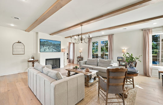 living room, fireplace, windows, double doors, chandelier, wood beams, hardwood flooring