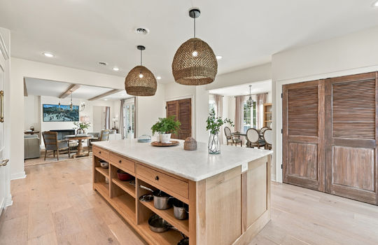 kitchen view into living room and dining spaces, kitchen island, hardwood flooring, pantry, recessed lighting