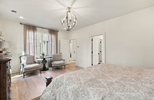 main level primary suite, hardwood flooring, door to hallway, door to ensuite