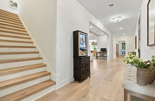 foyer, stairs to second level, hardwood flooring, views toward living room/mudroom
