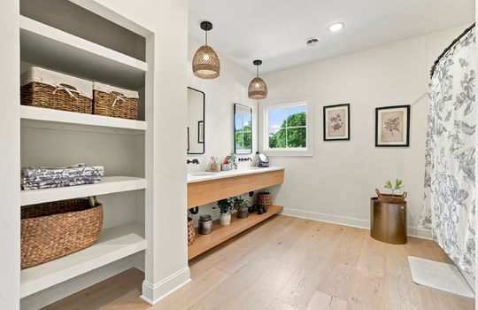 bathroom, built-in shelving, hardwood flooring, dual sink, shower/tub