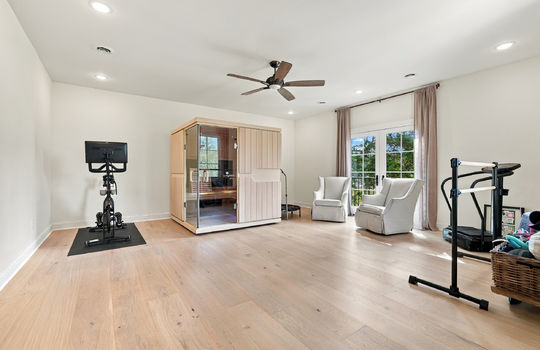 bedroom/fitness room, hardwood flooring, double doors open to balcony, recessed lighting, ceiling fan