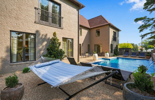 back yard, landscaping, in-ground heated pool, back of home, brick exterior