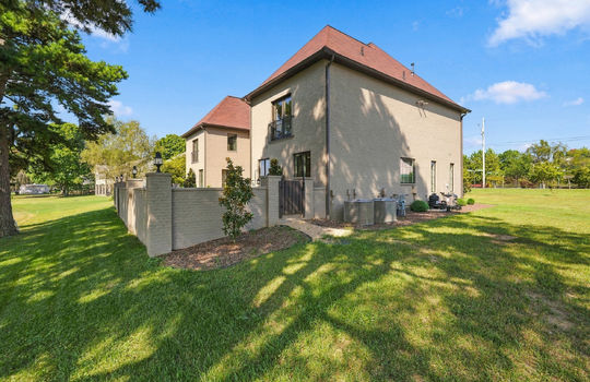 back of home, brick wall, brick exterior, side yard, landscaping