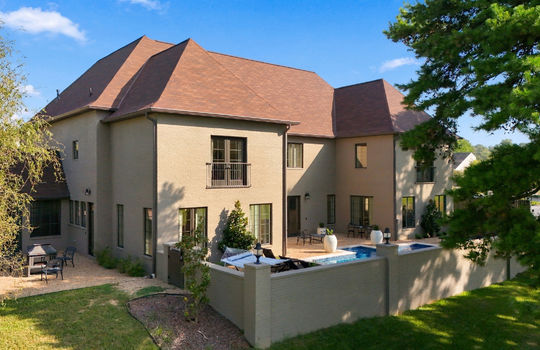 exterior back/side view of home, enclosed porch/sunroom, back yard, brick wall, pool, brick exterior, shingle roof