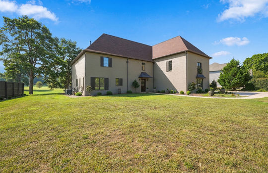left side view, front yard, sidewalk, landscaping, brick exterior, shingle roof, front door,
