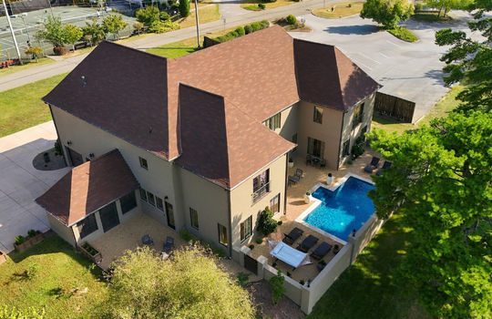 aerial view of home, driveway, side yard, back yard, pool, landscaping, shingle roof, exterior brick